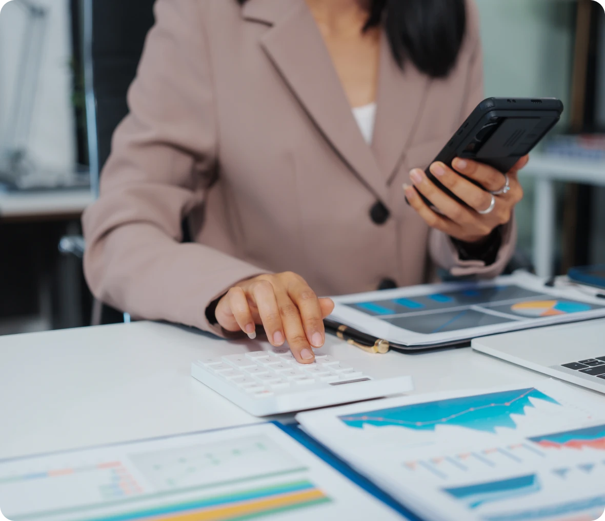 Businesswoman using calculator and smartphone