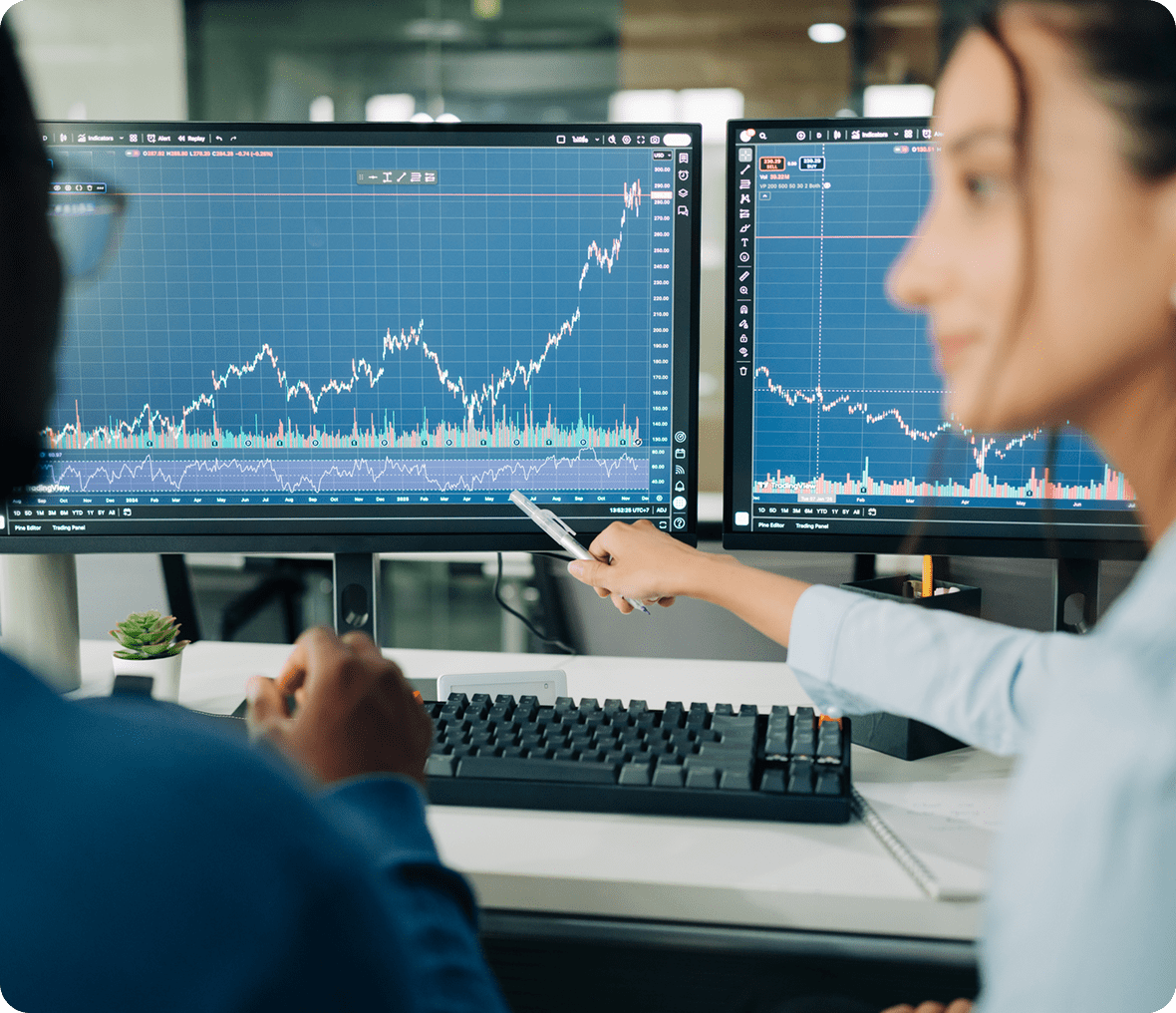 Two people analyzing stock market charts